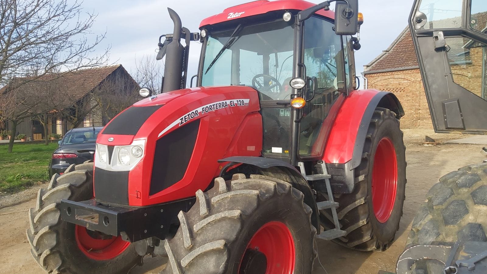 Red tractor parked near farmhouse